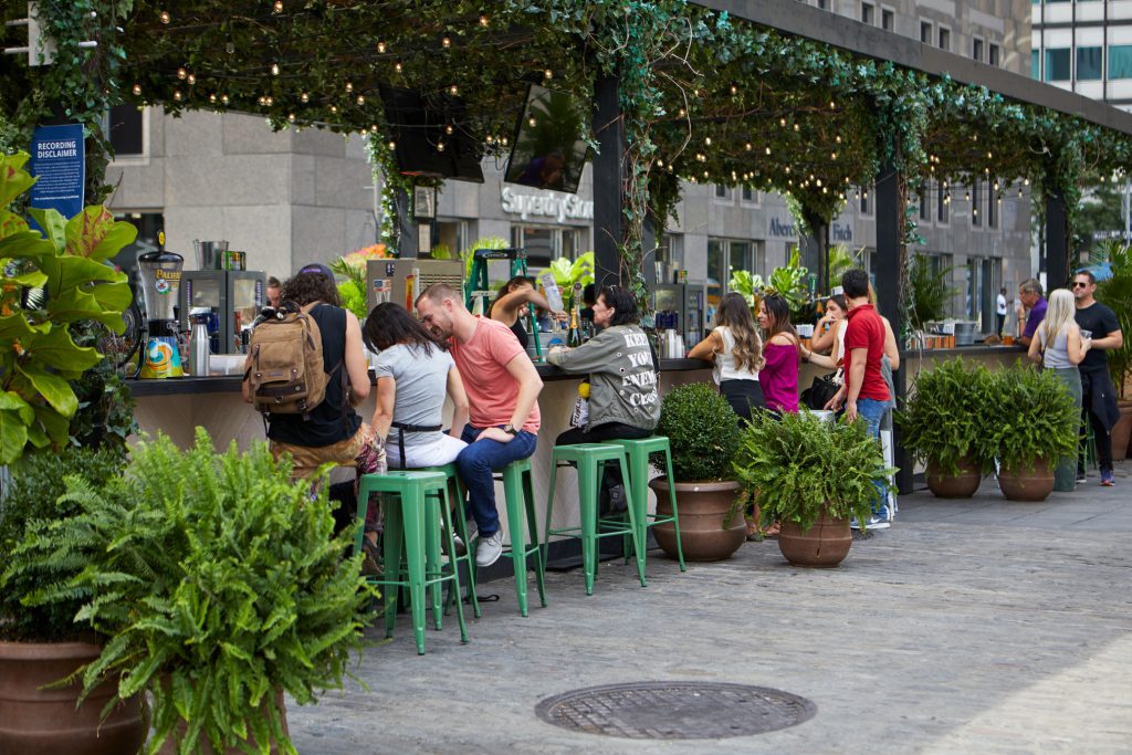 People sitting outside of a street cafe.